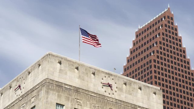 This video is about an establishing shot of the top of Houston city hall with American flag on top and nearby building in downtown Houston. This video was filmed in 4k for best image quality.