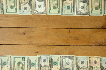 Background made with used dollars banknotes lying on rustic oak wooden table.
