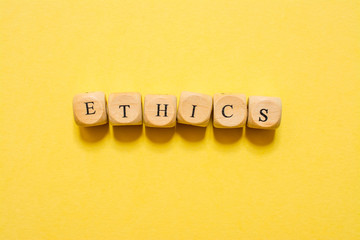 the word Ethics, text made with dice on yellow background