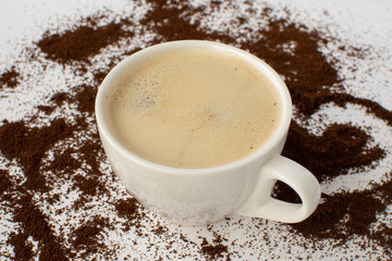 Espresso coffee on a white background with ground coffee. Still-life. Selective focus.