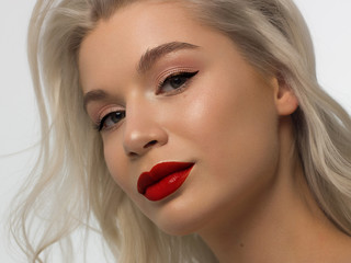 Closeup portrait of a woman with developing straight hair. Sweet tender young girl blonde. Natural lipstick, transparent clean skin. Skin care natural cosmetics in the spa salon or cosmetology.