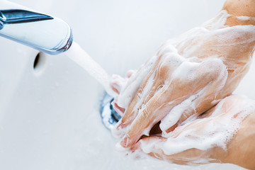Fototapeta premium Woman use soap and washing hands under the water tap. Hygiene concept hand detail.