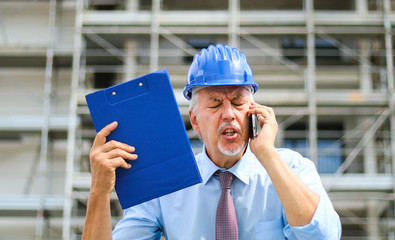Angry senior engineer shouting at the phone