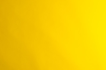 Yellow background made of real colored paper, illuminated by a soft light from the right.