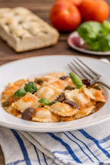 Vegetable ravioli with caper tomatoes and black olives
