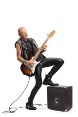 Man rock star playing a guitar with an amplifier