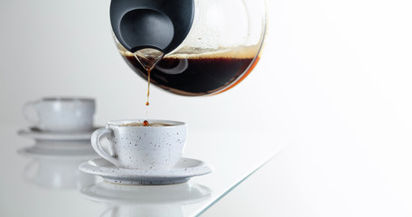 Coffee is poured from the coffee maker into a cup.