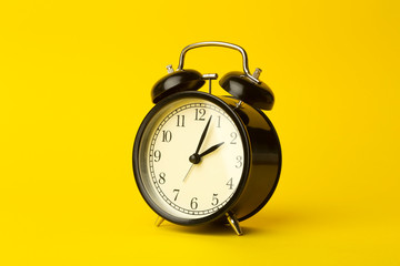 Time background concept. Vintage classic alarm clock on yellow empty background. Time management concept