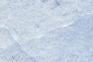 Close-up of cracked ice on a frozen lake in the winter, viewed from above. Abstract full frame background. Copy space, top view.