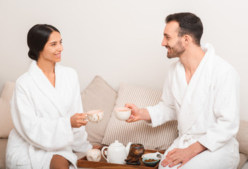 Man and a woman drinking wellness tea in a spa slon. Couple enjoys relaxation at resort and spa © Peakstock