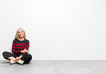 senior or middle age pretty woman laughing shyly and cheerfully, with a friendly and positive but...
