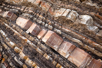 Close-up of rocky rock on a slice of a mountain. The concept of multi-million evolution and change of time periods. Archaeological concept. Background concept
