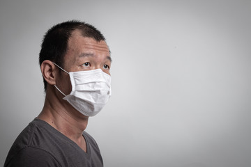 Asian man  wearing surgical  mask to prevent flu virus and  PM2.5 dust air pollution