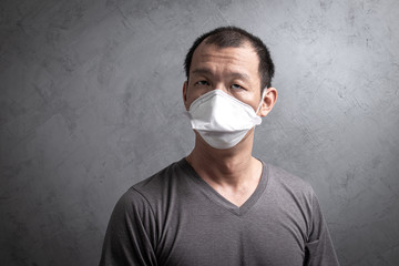 Asian man wearing surgical  mask to prevent flu virus and  PM2.5 dust air pollution