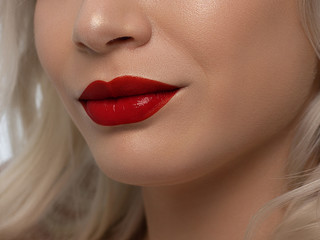 Fototapeta premium Sexual full lips. Natural gloss of lips and woman's skin. The mouth is closed. Increase in lips, cosmetology. red lipstick. Open mouth and with teeth. blonde hair.