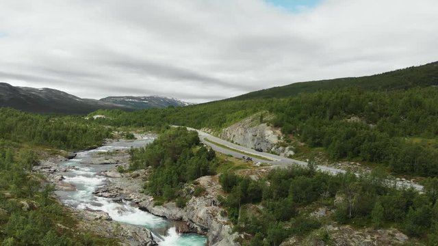 Beautiful wild river called Otta in Norway.
Filmed with drone, flown away.
With a road and cars in the background.