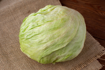 Green fresh iceberg lettuce on a wooden background.