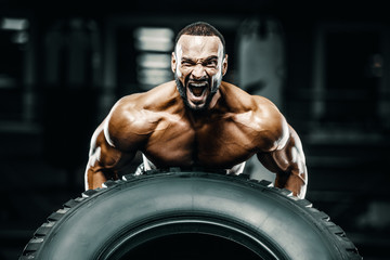Bodybuilder strong man flipping tire workout
