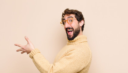 young cool man smiling, greeting you and offering a hand shake to close a successful deal,...