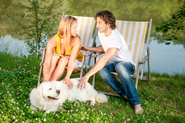 Young couple in love relaxing together with their golden retriever dog.