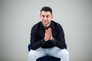 Young businessman guy in black shirt and white trousers on a white background