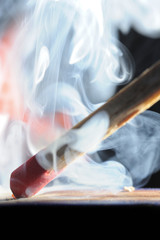 Matchstick ignites with the help of the matchbox with beautiful flames and smoke.