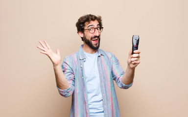young bearded man with a electric razor