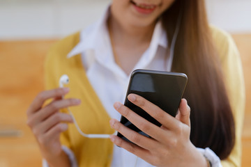 A young woman listen to online music from mobile phone.