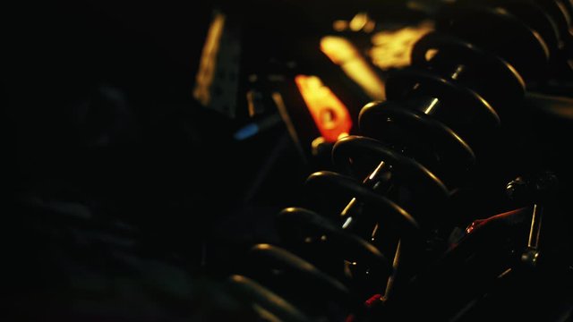 Close up of coil spring used as a part of car or motorcycle suspension system. Stock footage. Details of machines, professional equipment and repair parts.