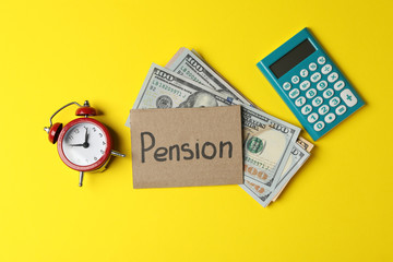 Inscription Pension, money, calculator and alarm clock on yellow background, top view