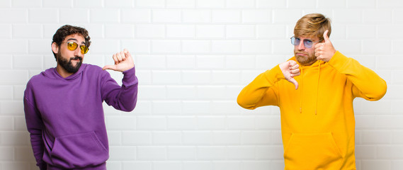 young cool men feeling confused, clueless and unsure, weighting the good and bad in different...