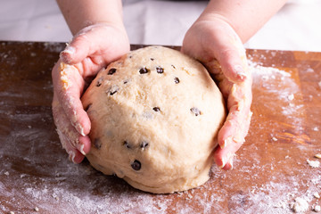 Mujer amasando masa para galletas de chocolate en tabla de madera con rodillo masa en bola