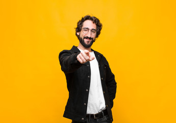 young crazy handsome man pointing at camera with a satisfied, confident, friendly smile, choosing...