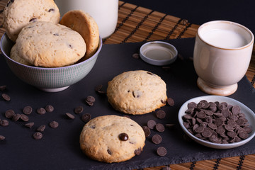 bol con galletas de chocolate pepitas leche en pizarra con vela leche tapón en esterilla en una...