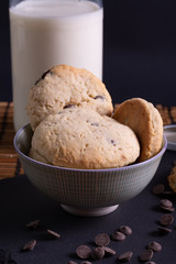 bol con galletas de chocolate pepitas leche en pizarra con vela leche tapón en esterilla en una...
