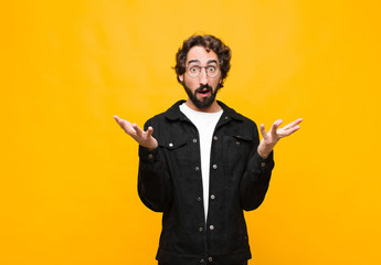 young crazy handsome man feeling extremely shocked and surprised, anxious and panicking, with a...