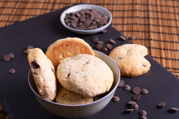 bol con galletas de chocolate pepitas leche en pizarra con vela leche tapón en esterilla en una...