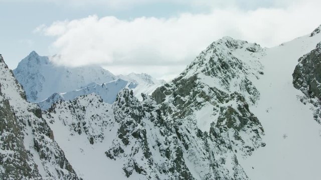 The snow covered peaks, steep cliffs and glacial valleys of the Madison mountain range in southwestern Montana