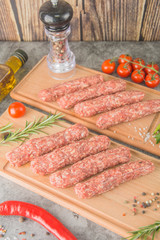 Raw beef sausages. Mititei - Romanian cuisine, on wooden boards with spices. 