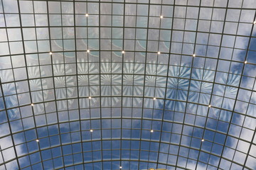 Obraz premium Beautiful light spinning reflection on the glass ceiling against the blue sky. 