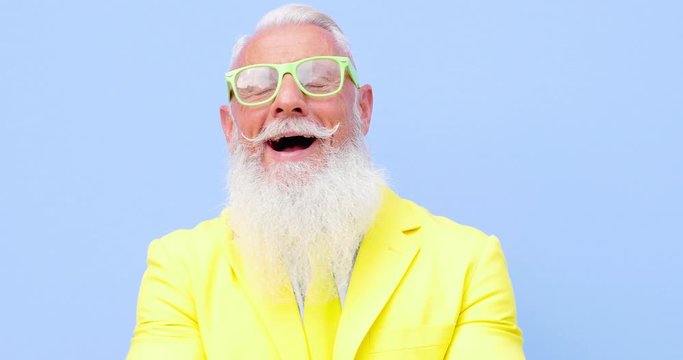 Senior man hipster with funny colored outfit on colored backgrounds