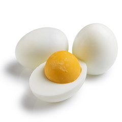 three boiled chicken eggs are lying nearby, one egg is cut in half, concept, close-up