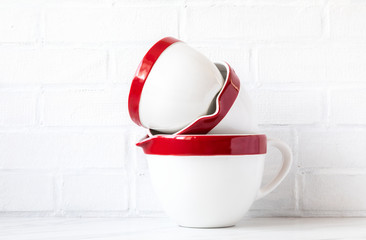 Bowls for mixing ingredients and making dough. Red-white on a brick wall background.