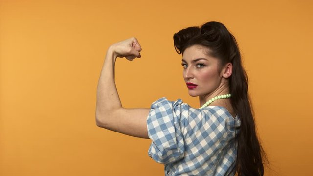 Strong pin up woman showing biceps and winking at camera