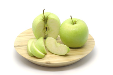 Green apples on a plate isolated on a white background.