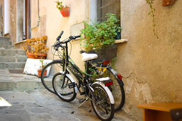 Fototapeta na wymiar Two vintage bicycles are locked together in the old town of Monterosso al Mare, Italy, a picturesque town of the Cinque Terre.