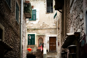 A picturesque dark alley with a door and alcove with statue in the medieval hilltop village of Dolceacqua, Italy.