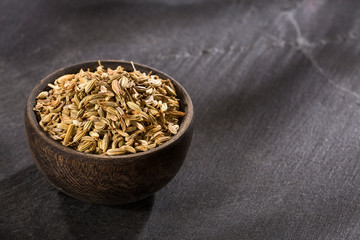 Fennel seeds in a small wooden bowl - Foeniculum vulgare
