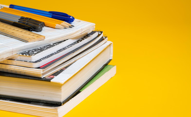 School books and supplies on a yellow background