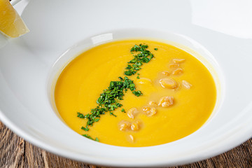 Serbian cuisine. Macedonian cream soup of chickpeas, carrots, onions, garlic, with chicken. Serving dishes in a restaurant in a white plate. background image, copy space text